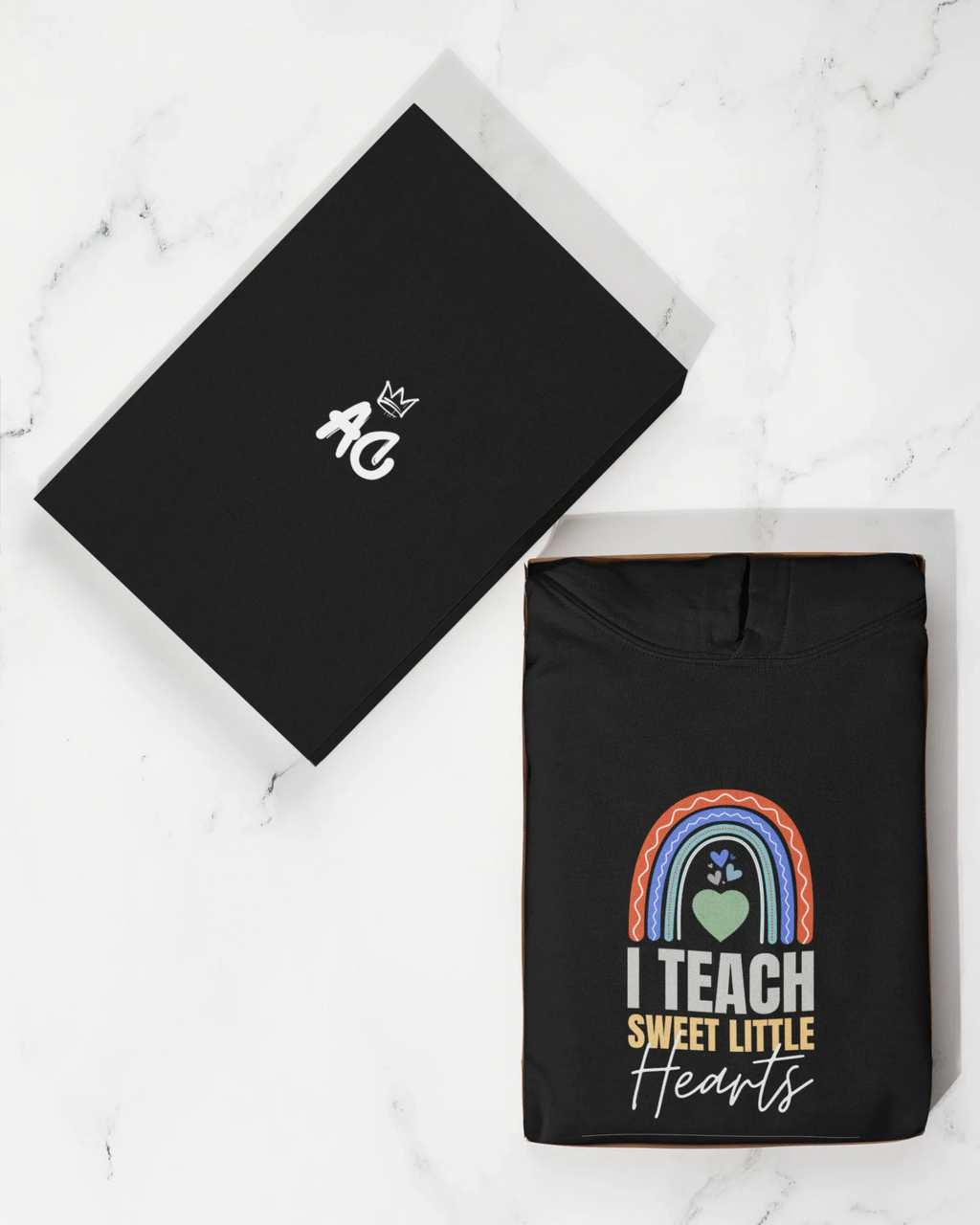 Black hoodie with front rainbow heart graphic; flat accessory card with small hand icon