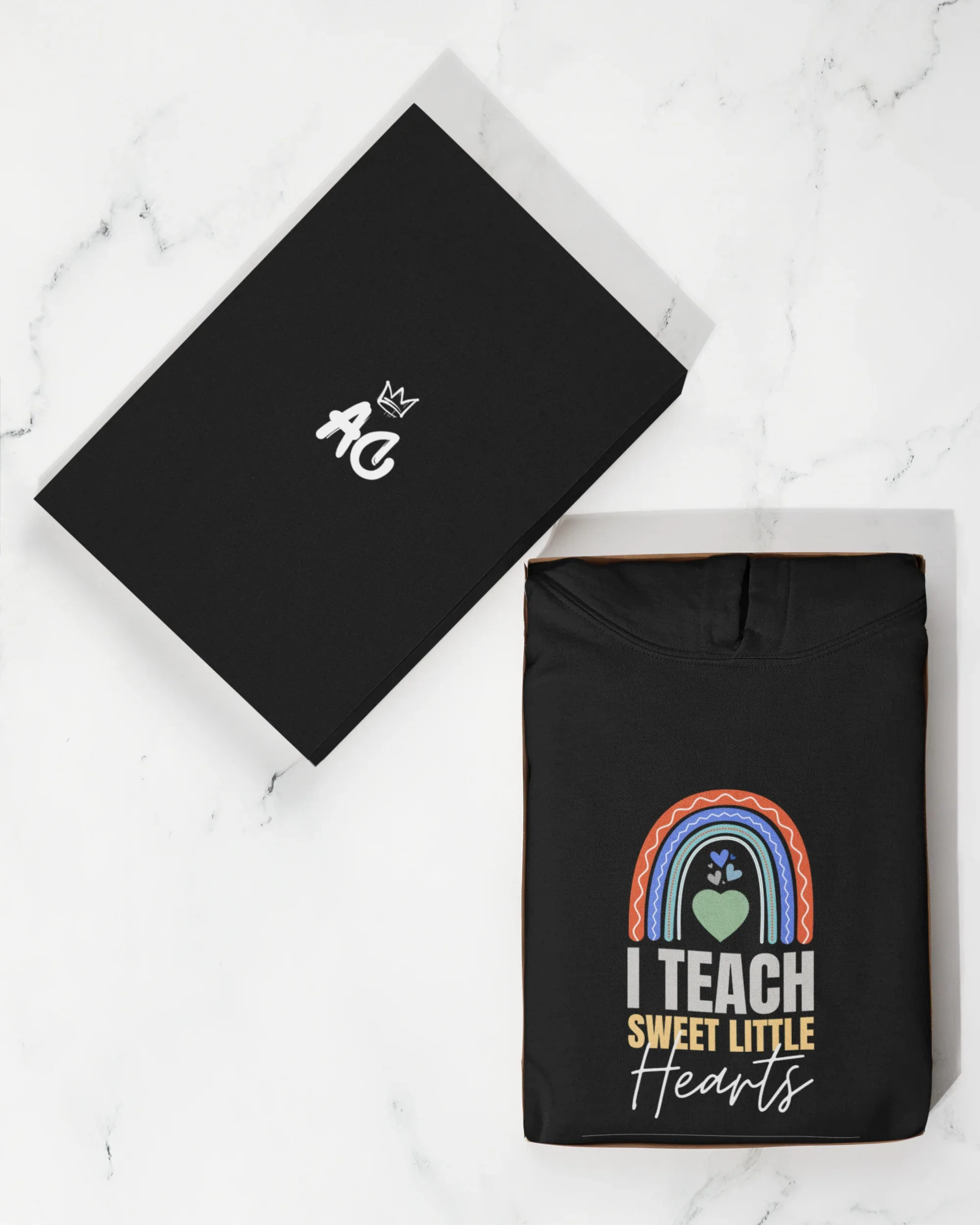 Black hoodie with front rainbow heart graphic; flat accessory card with small hand icon