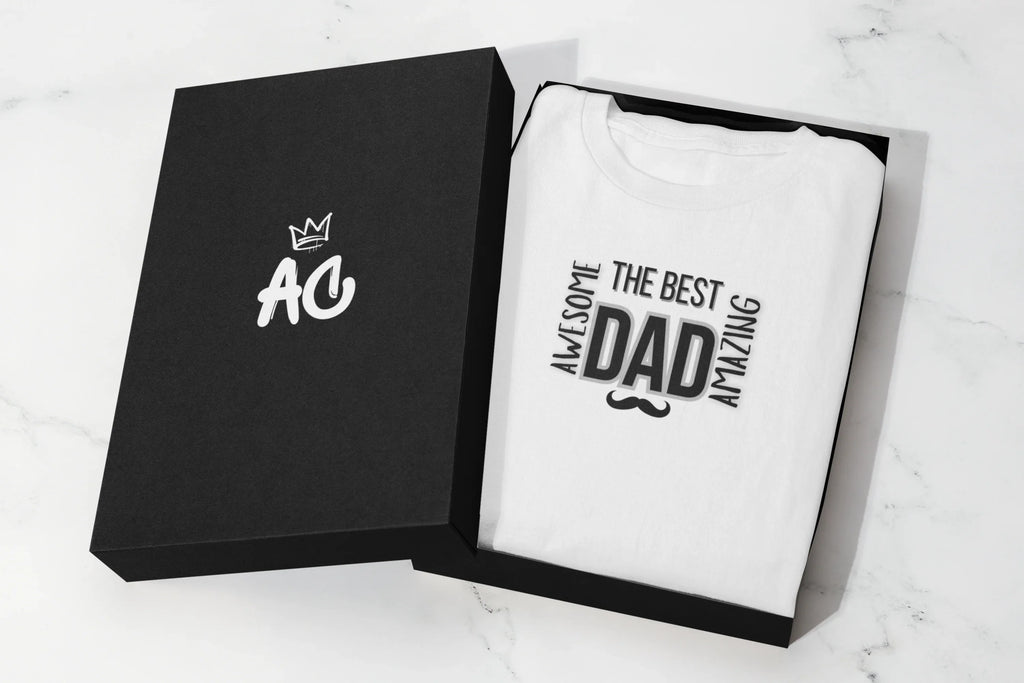 Folded white heavy cotton T-shirt in a black gift box, featuring “The Best Dad” graphic.