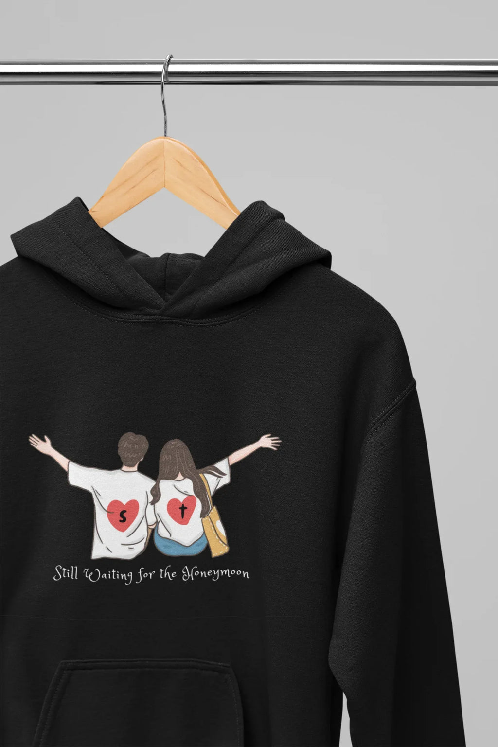 Black pullover hoodie with drawstring hood and couple graphic on chest