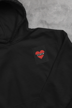 Black unisex hoodie with heart embroidery name patch reading SARAH