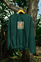 Forest green sweatshirt with crew neck and “Like a Pine” logo print