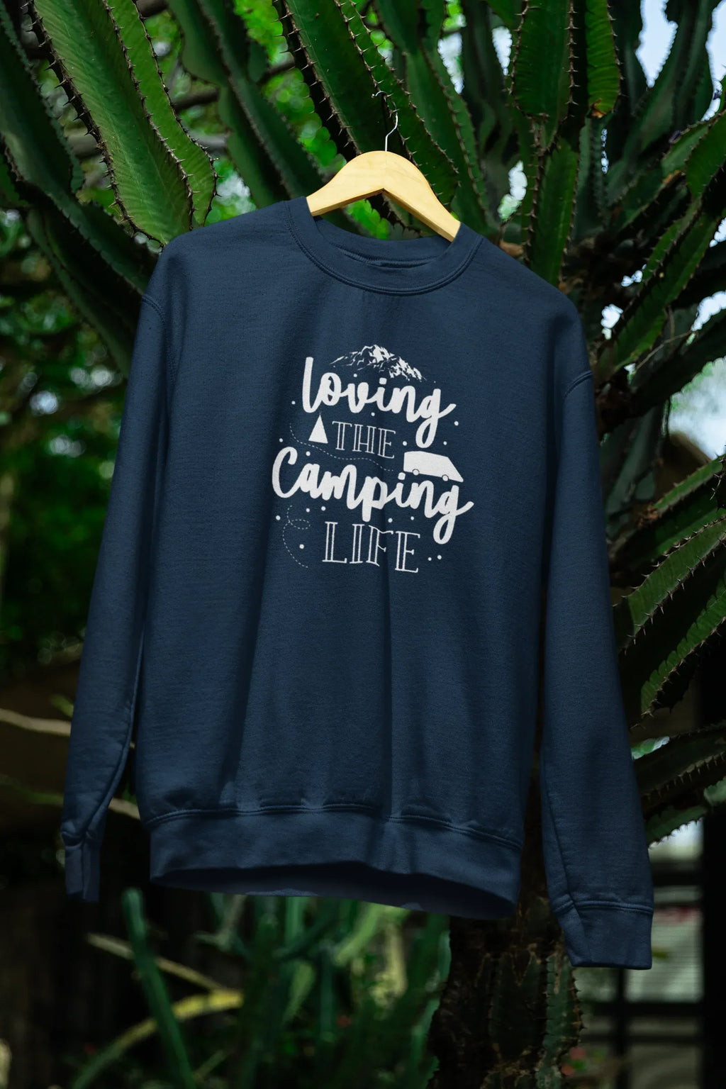 Navy crewneck sweatshirt on hanger with white "Loving the Camping Life" graphic