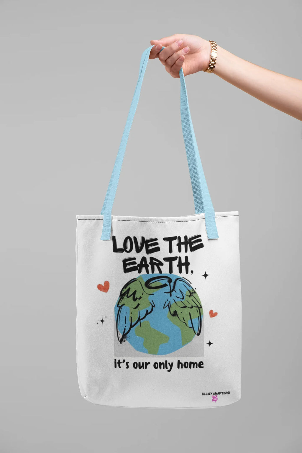 White tote bag with “Love the Earth” text and globe illustration, light blue handles