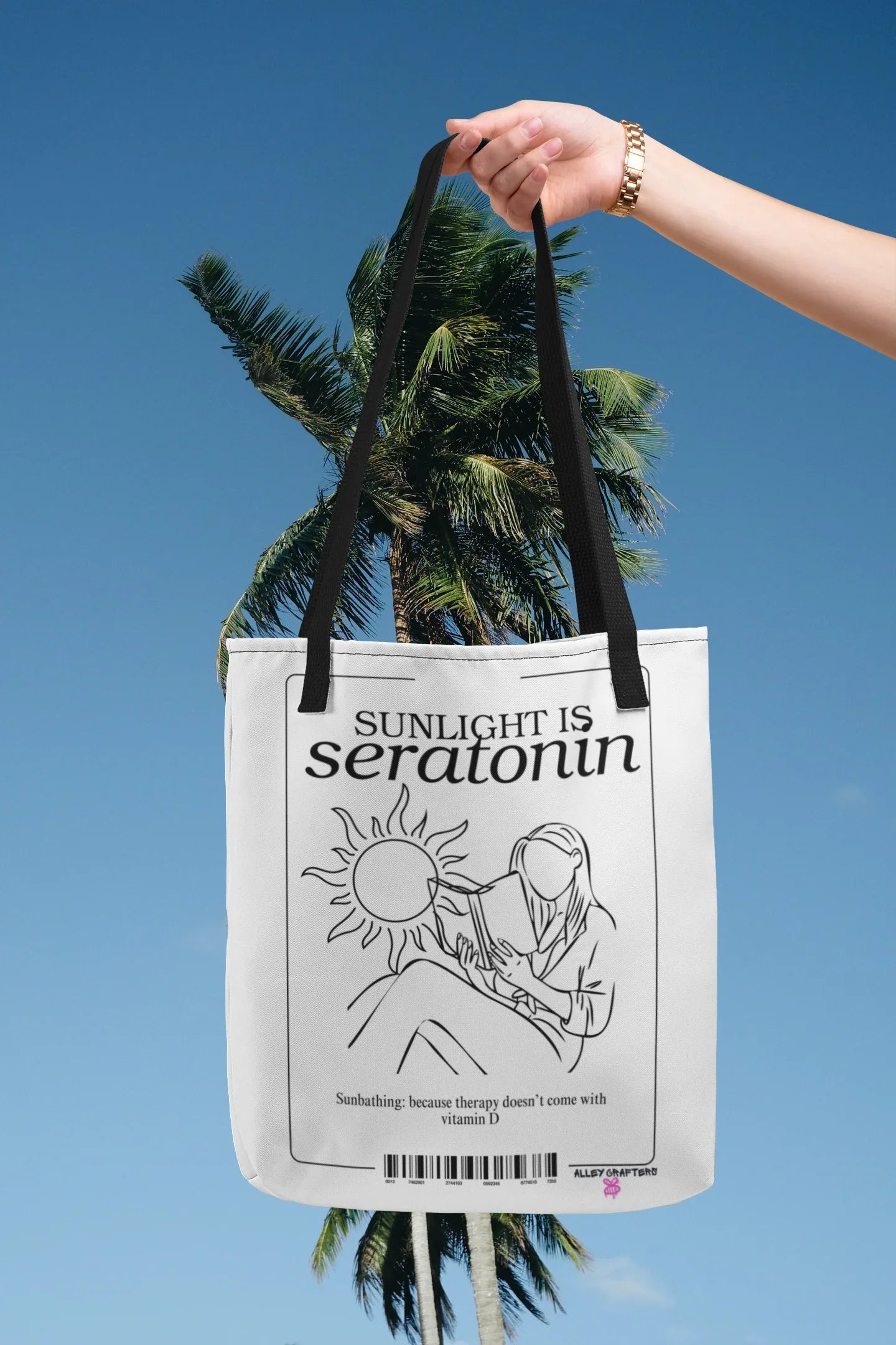 White tote bag hanging from straps with black line art on the front panel