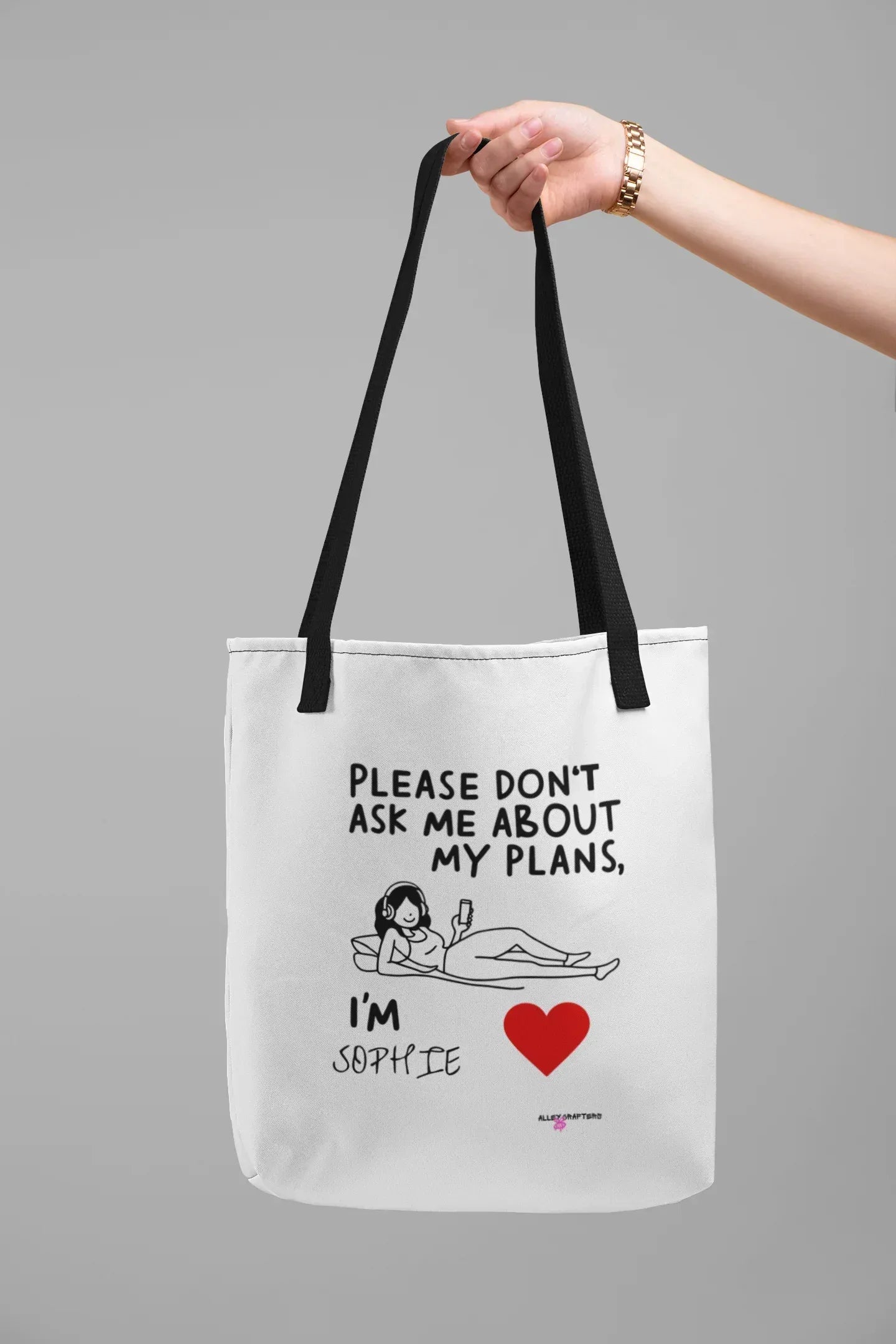 White canvas tote bag with black handles and “Please don’t ask me about my plans” quote