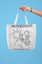 White tote bag held up by handles, featuring black sun-and-serotonin line artwork