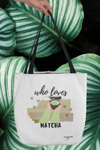 White tote bag held over green striped fabric, with “who loves MATCHA” graphic.