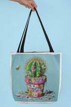 Tote bag with cactus artwork, light blue panel, black handles