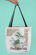 Black-handled white tote bag with green plant graphic and 'Plant vibes only' text