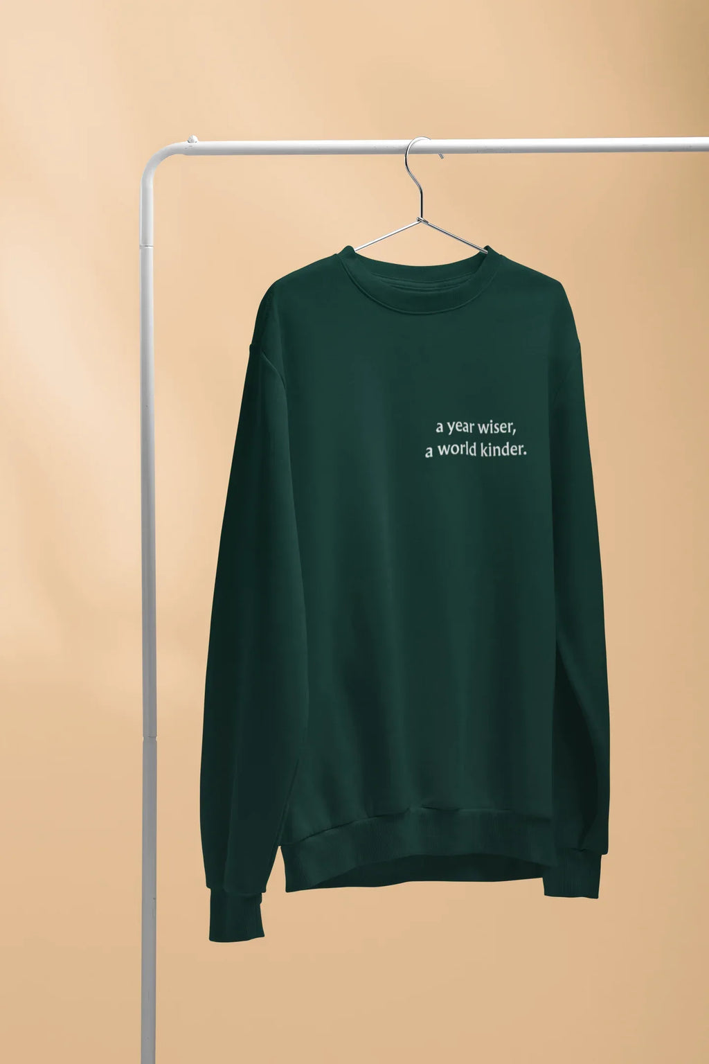 Dark green crewneck sweatshirt with 'a year wiser, a world kinder.' print