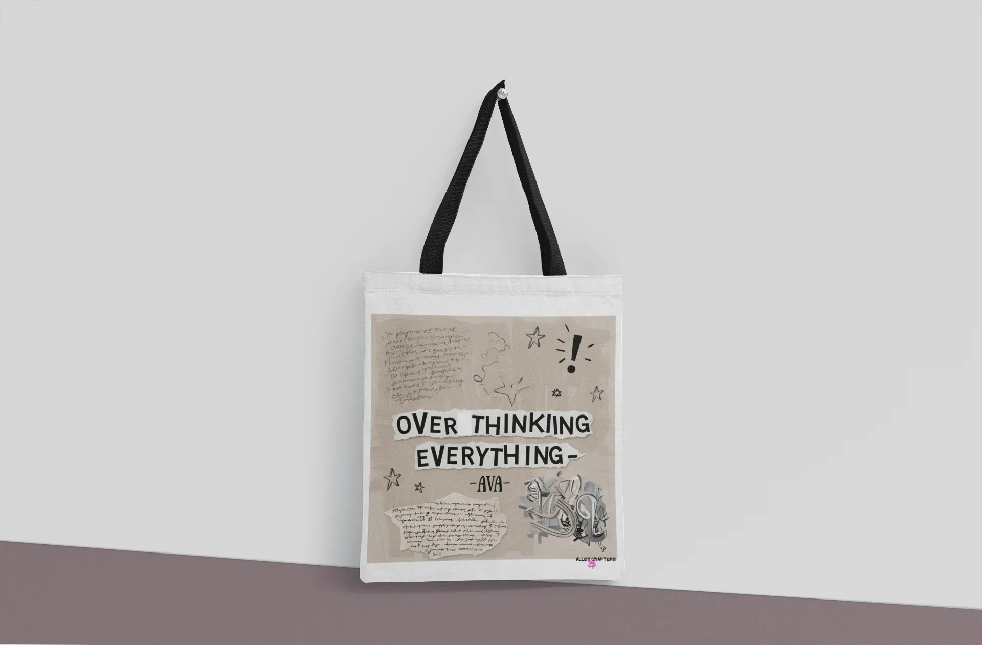 White tote bag with black straps and front print reading 'OVER THINKING EVERYTHING'