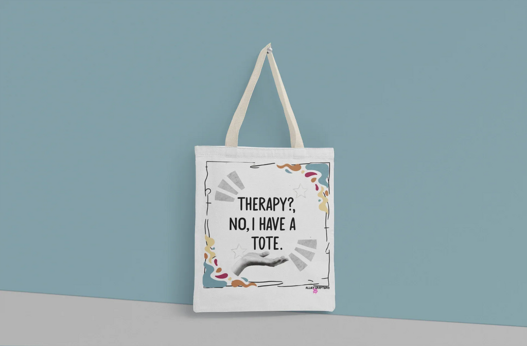 White tote bag with “Therapy?, No, I have a Tote” print and colorful border, long handles