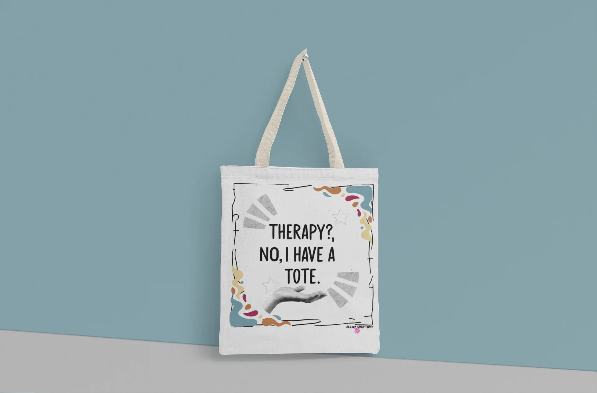 White tote bag with “Therapy?, No, I have a Tote” print and colorful border, long handles