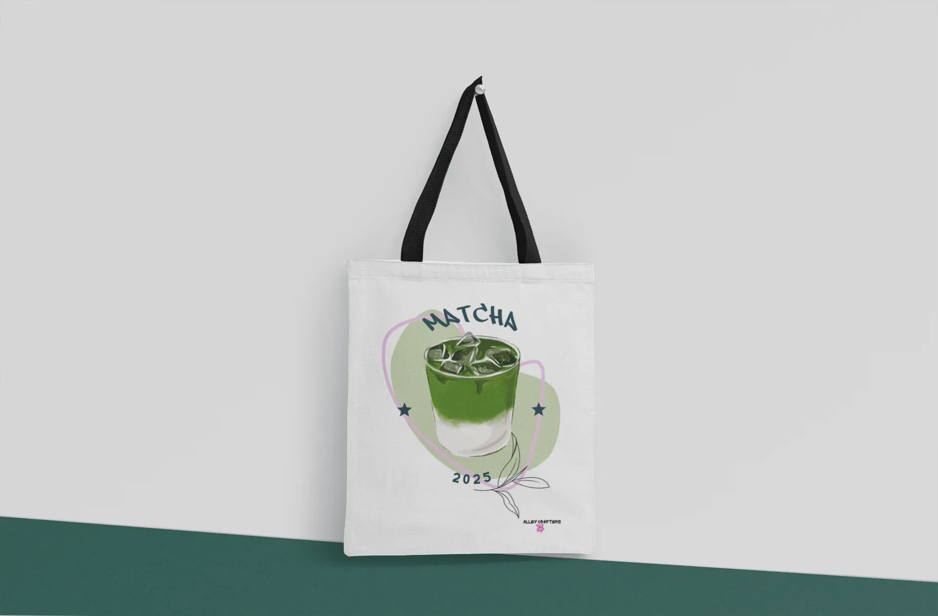 White tote bag with black base straps and matcha drink print on front