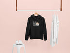 Black hoodie sweatshirt on a hanger with hood and “Not a Regular Mum, Coffee Mum” print