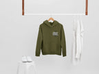 Olive green graphic hoodie on a hanger with small chest “Mildly Feral” logo