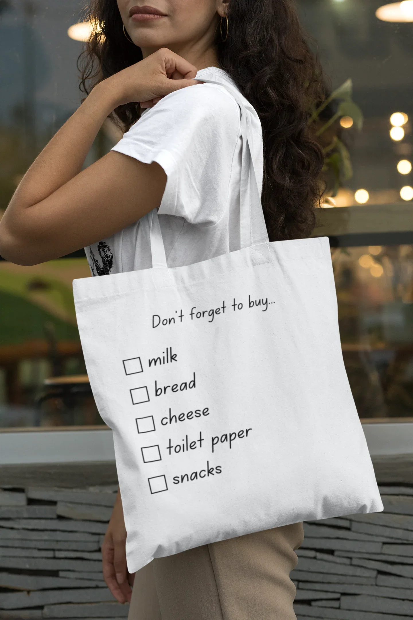White tote bag with 'Don't forget to buy' checklist: milk, bread, cheese, toilet paper, snacks.