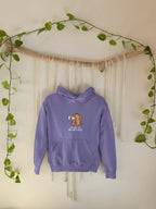 Light purple hooded sweatshirt hanging with woman megaphone graphic and front pocket