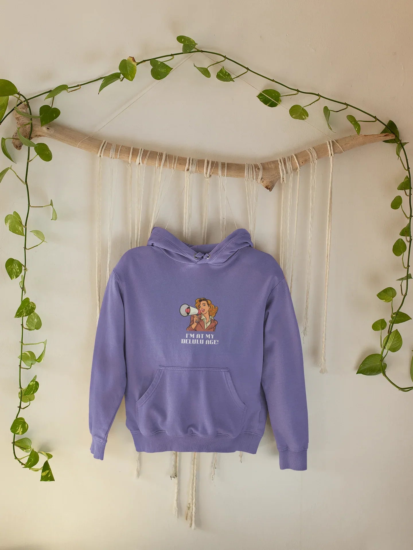 Light purple hooded sweatshirt hanging with woman megaphone graphic and front pocket