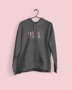 Charcoal hoodie with heart monogram graphic and small red accent, hanging view