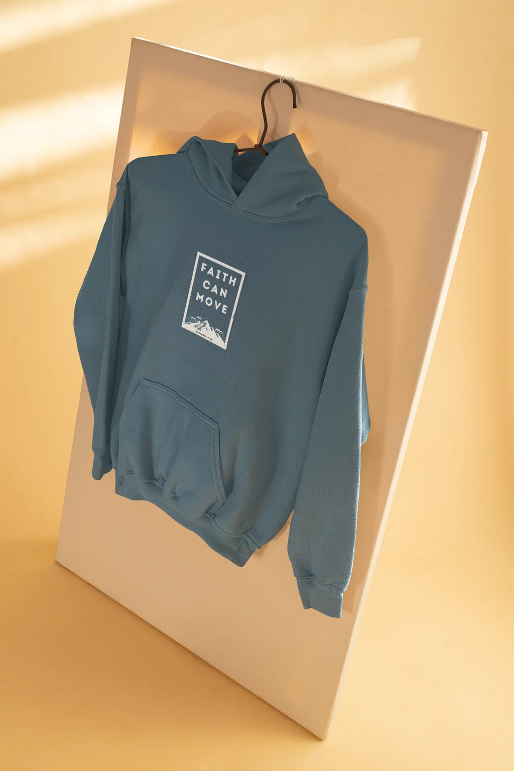 Light blue hoodie sweatshirt on hanger, folded over with hood and front faith graphic