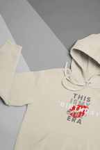 Cream pullover hoodie close-up with "THIS IS MY BIRTHDAY GIRL ERA" front graphic
