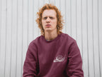 Burgundy sweatshirt with a white snail graphic on the front chest.