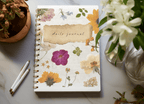 A5 wirebound softcover notebook with floral cover and lined paper visible.