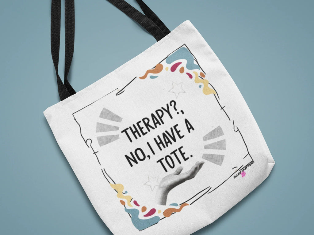 White tote bag with black text print and colorful confetti-style border, dark handles