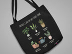 Black tote bag with white handles, plant collage and 'THINGS I DO IN MY SPARE TIME'.