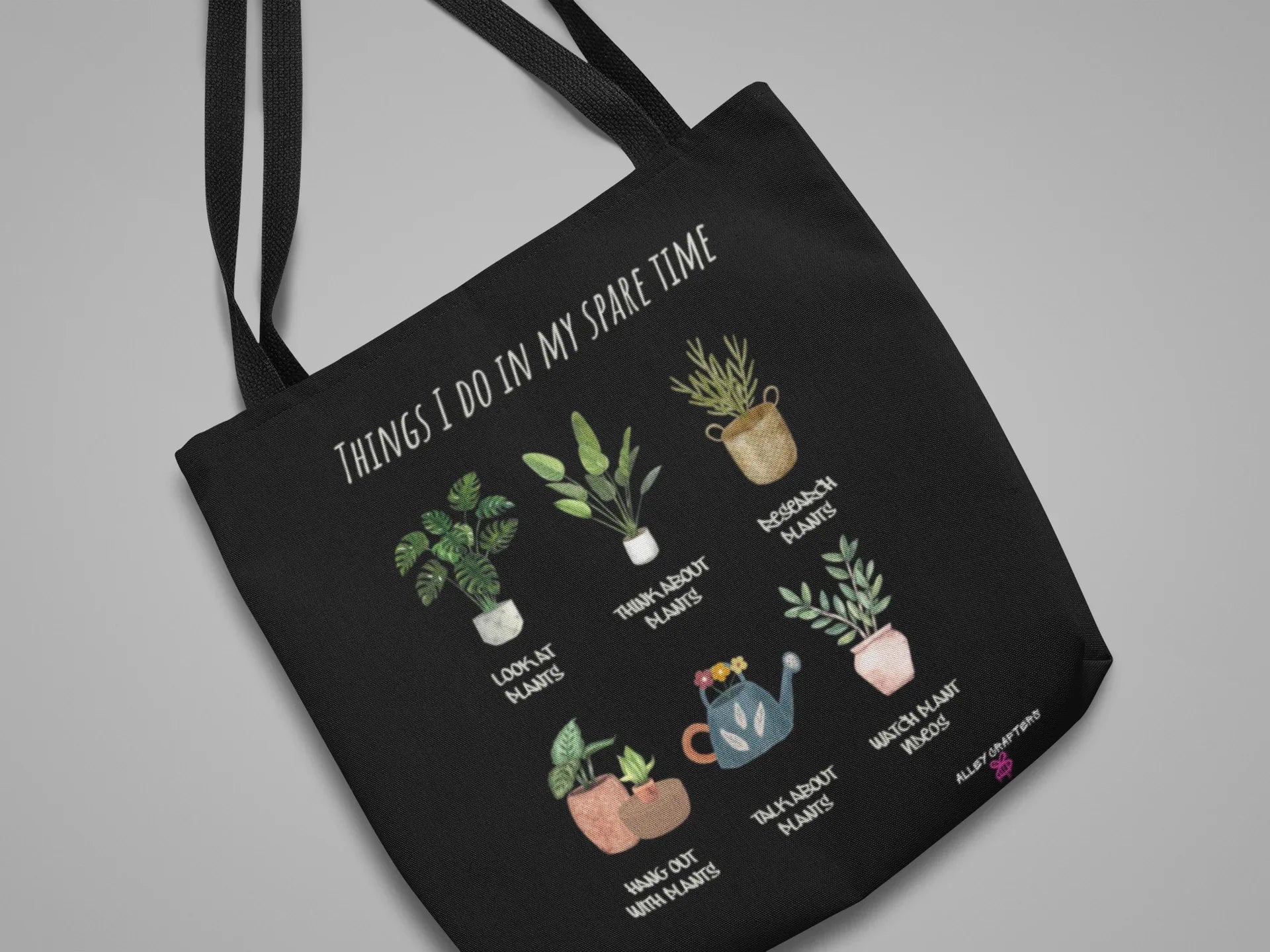 Black tote bag with white handles, plant collage and 'THINGS I DO IN MY SPARE TIME'.