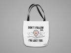 White canvas tote bag with black text "DON'T FOLLOW ME" and red location-pin illustration