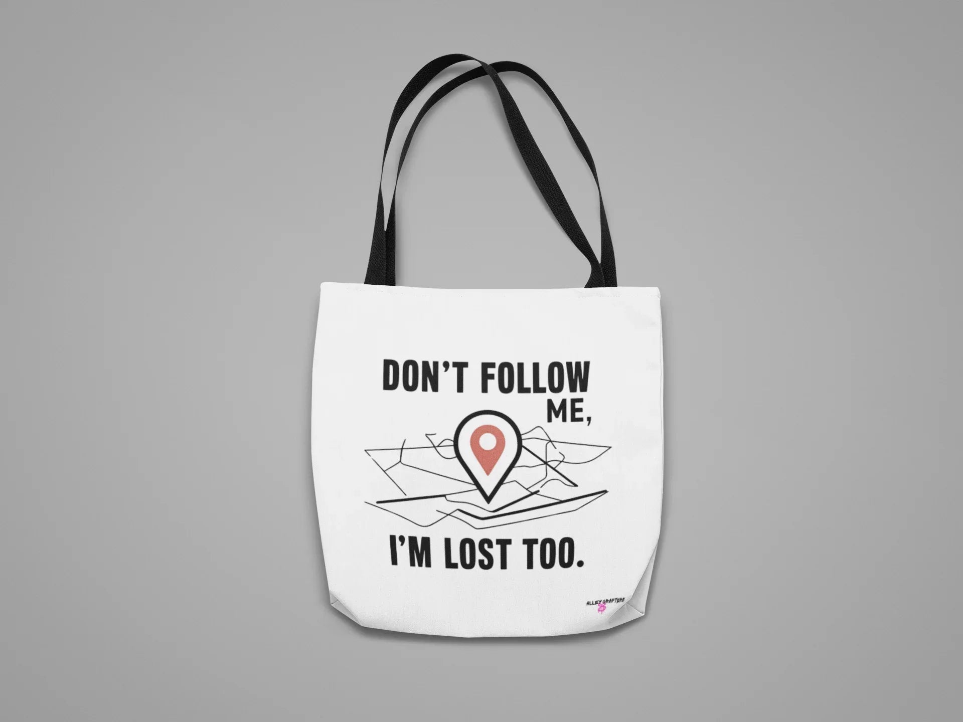 White canvas tote bag with black text "DON'T FOLLOW ME" and red location-pin illustration