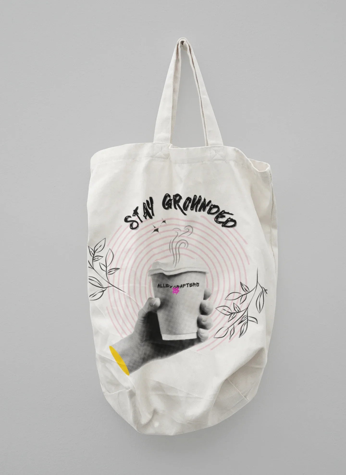 White canvas tote bag with beige handles and Stay Grounded coffee cup graphic