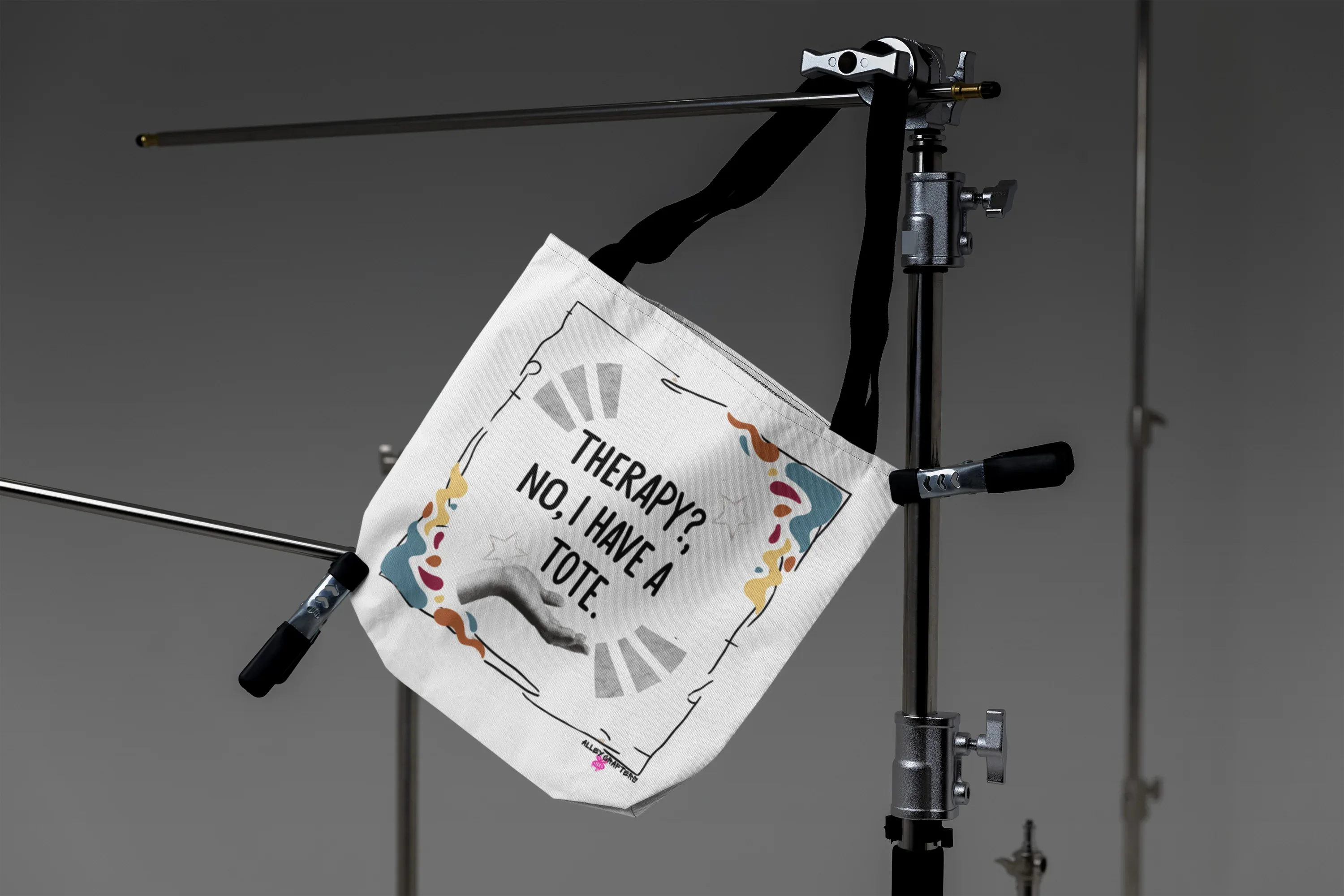 White tote bag with “Therapy?, No, I have a Tote” print, suspended with dark strap