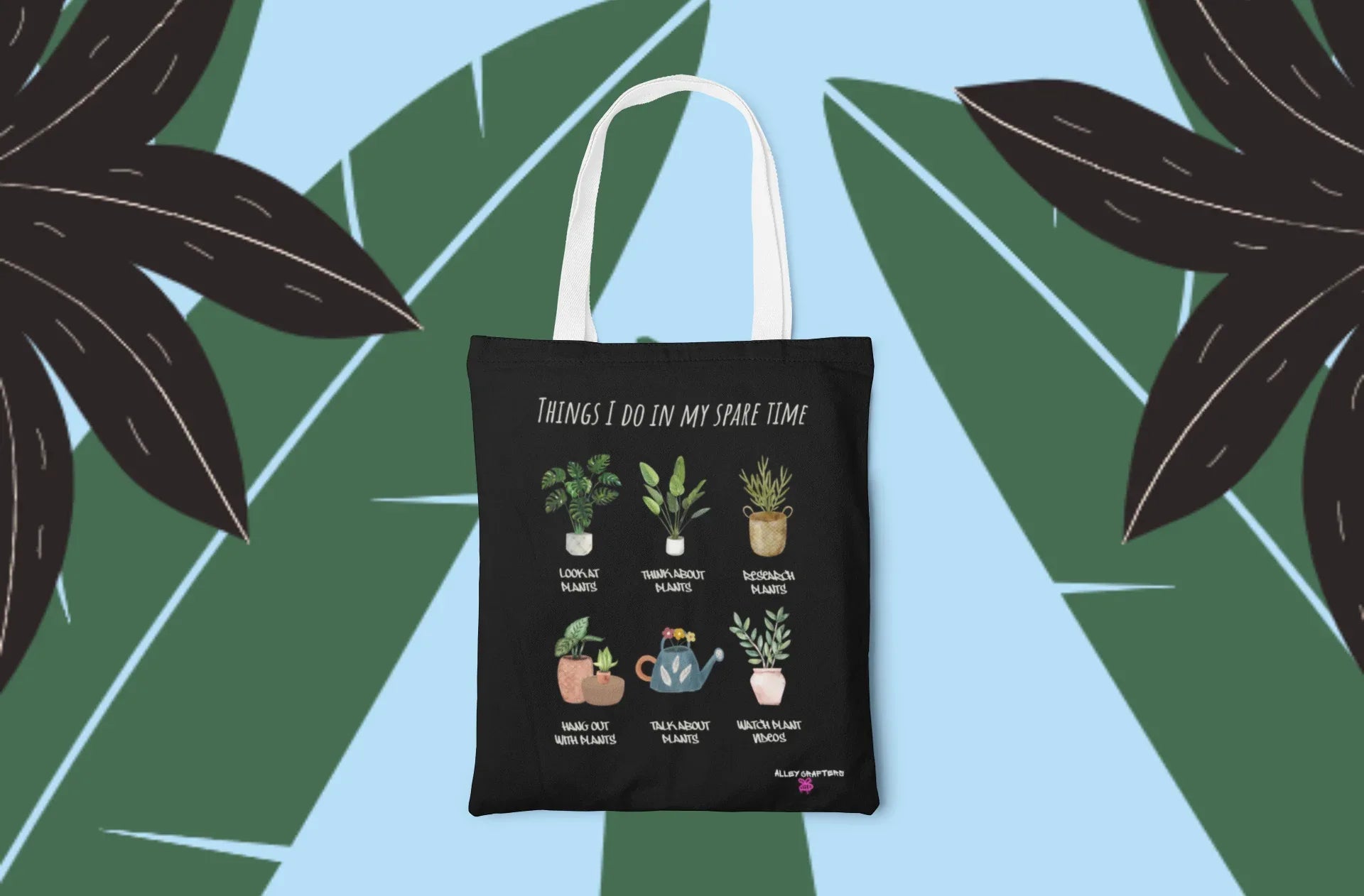 Black tote bag shown front-on with plant illustrations and 'THINGS I DO IN MY SPARE TIME'.