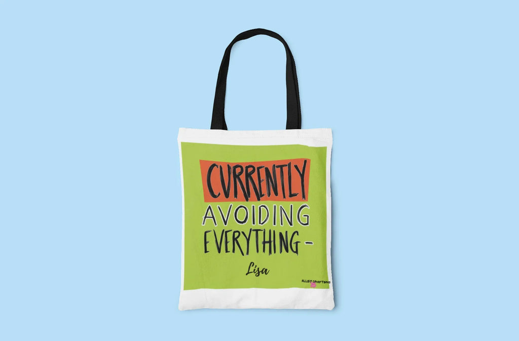 White tote bag with green front panel showing 'Currently Avoiding Everything-' text
