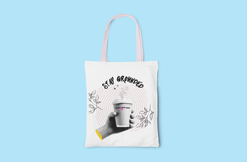 White tote bag with light blue handles and Stay Grounded coffee cup print