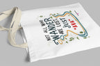 White canvas tote bag with long handles, close-up of colorful “wander” quote print