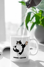 White coffee mug with cat graphic and 'DRINK COFFEE' text on front.