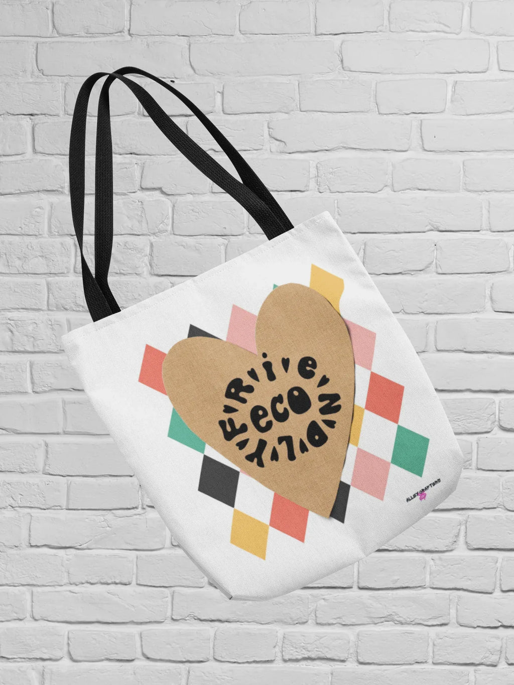 Heart-print tote bag with tan heart graphic, multicolor diamond pattern, white canvas, black handles