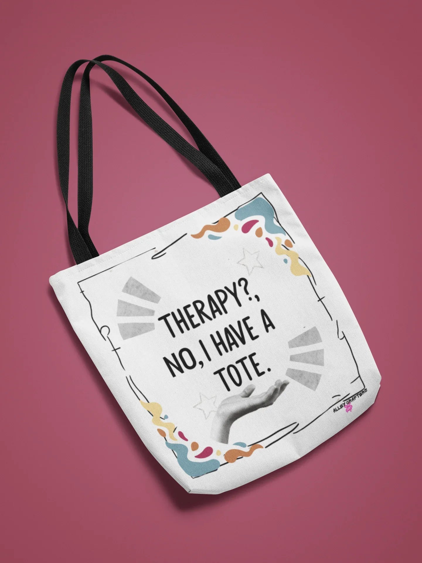 White tote bag with bold “Therapy?, No, I have a Tote” print and colorful border, black strap