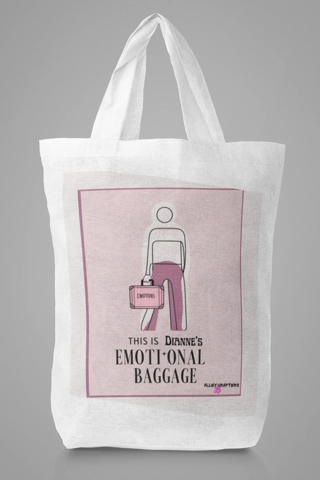 White canvas tote bag with pink centered graphic and bold text beneath.