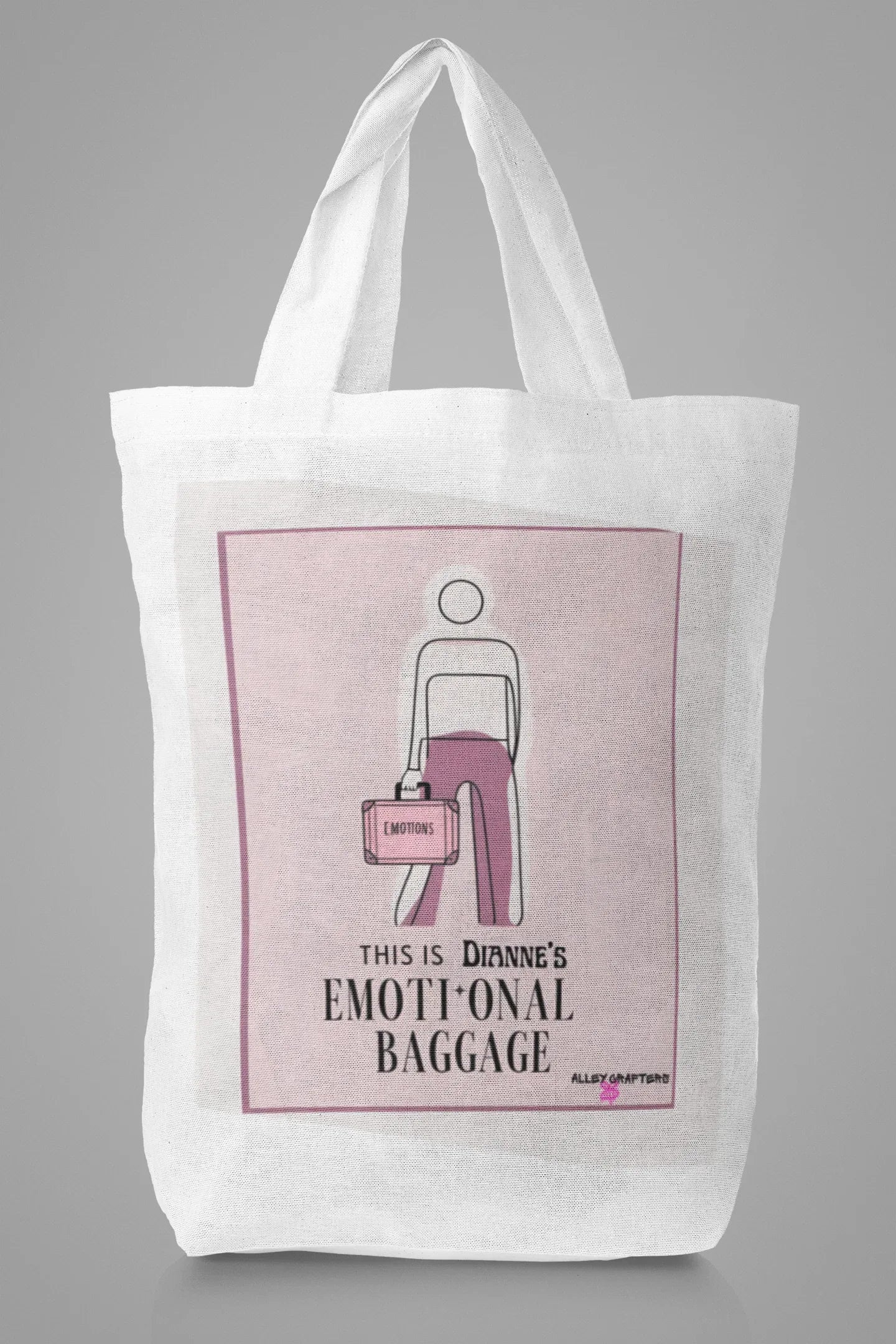 White canvas tote bag with pink centered graphic and bold text beneath.