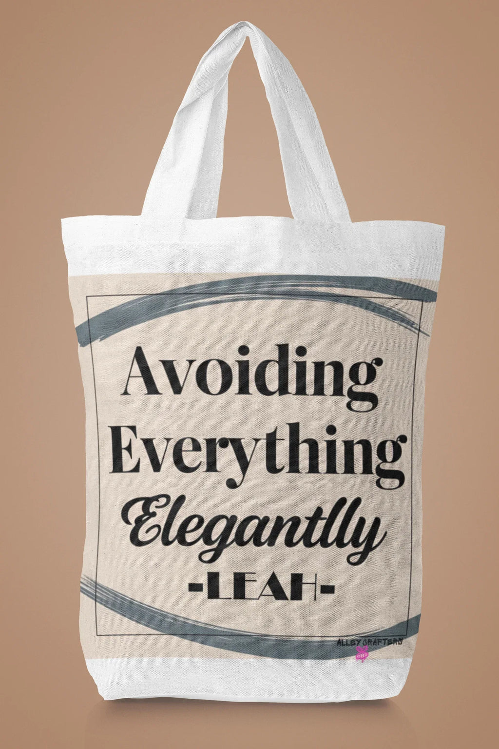 White canvas tote bag with large "Avoiding Everything Elegantly" lettering