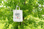 White canvas tote bag with long handles, colorful “wander” quote centered on front