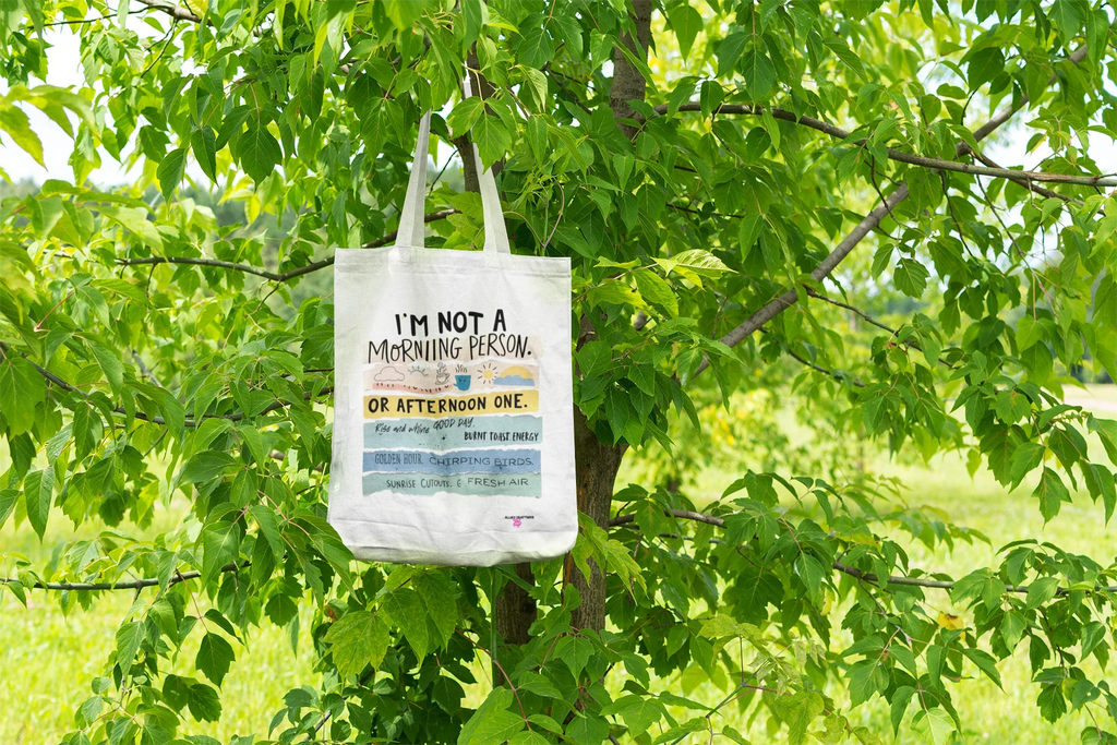 Beige canvas tote bag with printed text and graphic on the front