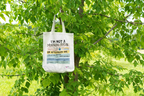Beige canvas tote bag with printed text and graphic on the front