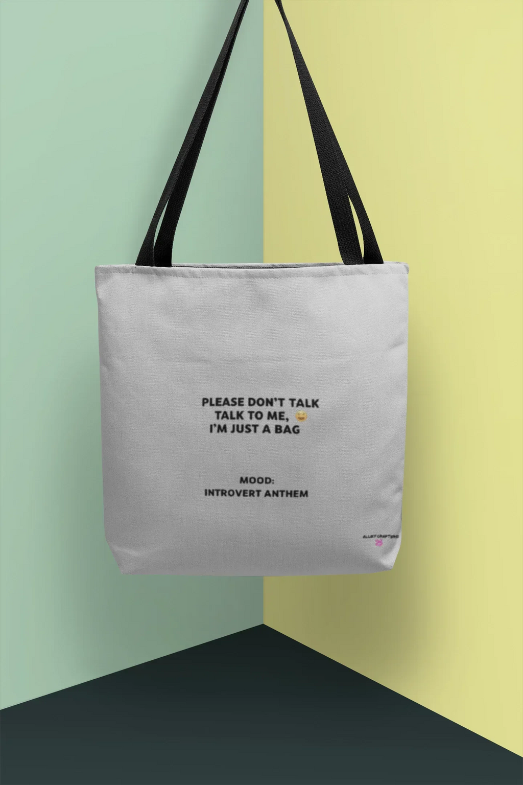 White canvas tote bag with black handles and front slogan print